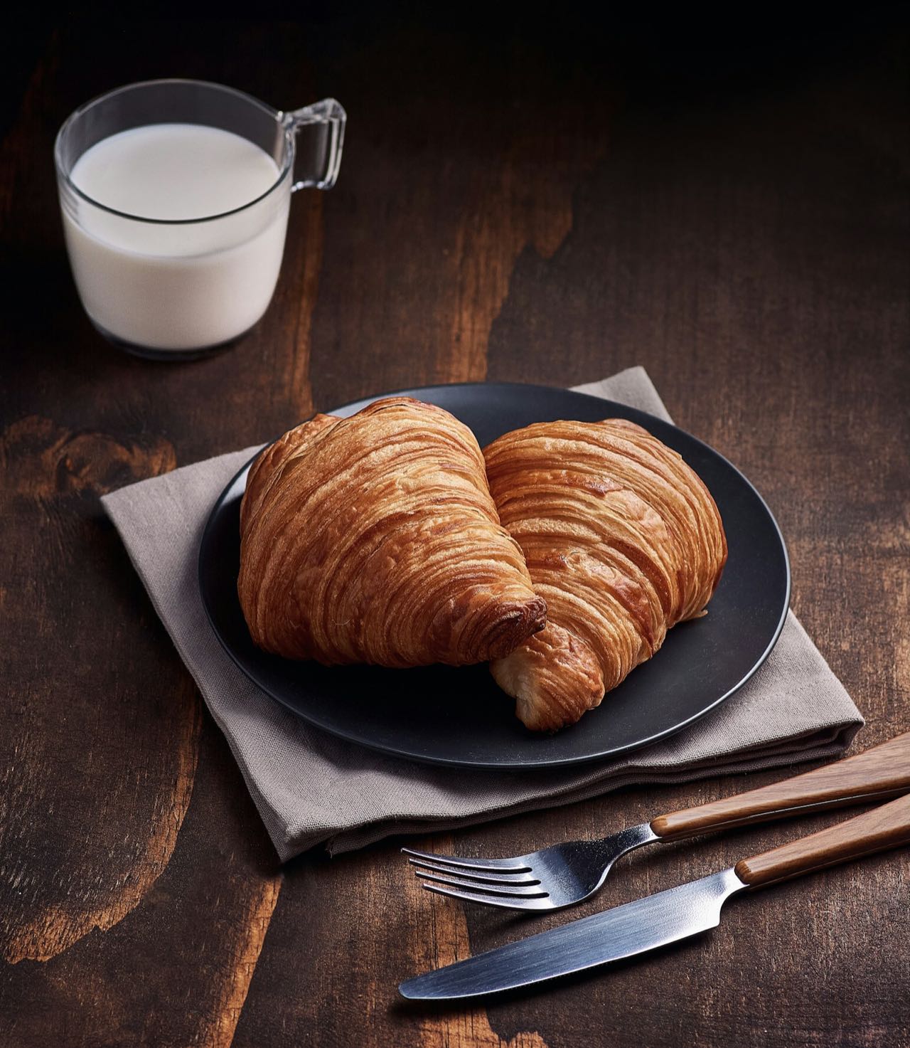 Deux croissants dans une assiette et un verre de lait