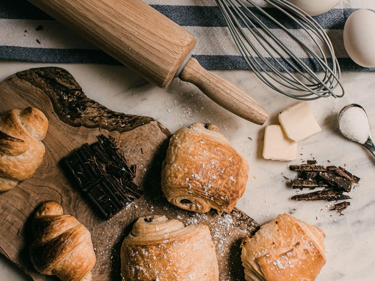 Croissants et pains au chocolat sur une planche en bois